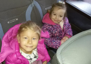 Widok na dwie dziewczynki siedzące w autokarze.